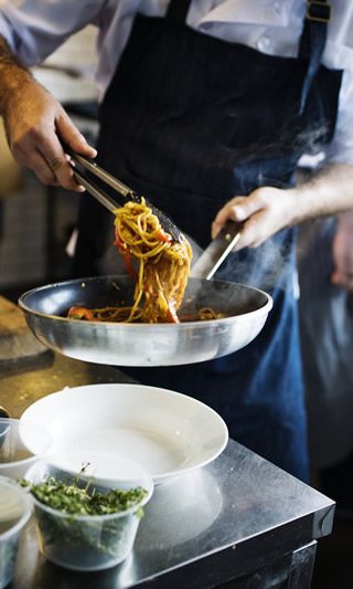 Chef salteando pasta en sartén de aluminio ALSASA